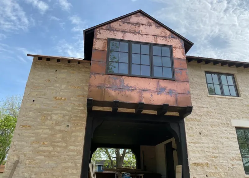 Copper metal panel facade on a stone building for Skylight Installation in Estero